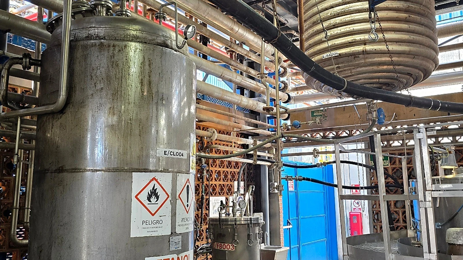 Interior de la planta de proceso en Murcia: columnas, tuberías y equipos bajo seguimiento de confiabilidad de TGD Company.